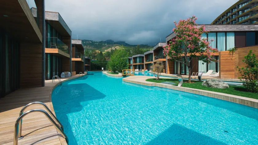 Современные деревянные виллы у большого бассейна на территории курорта